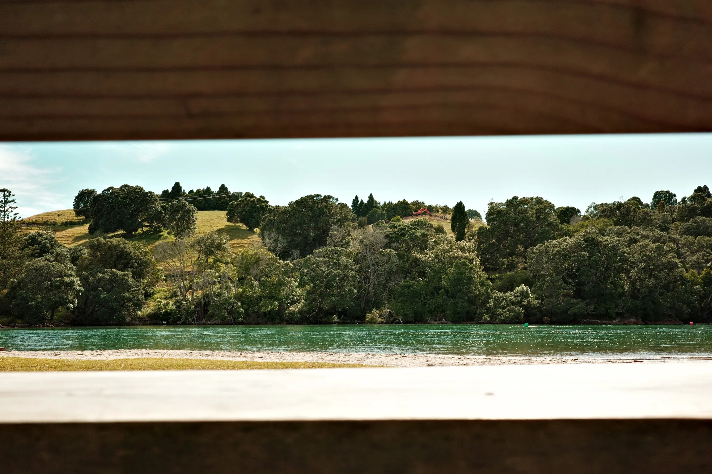 Photo of a bay through a slat in a bench