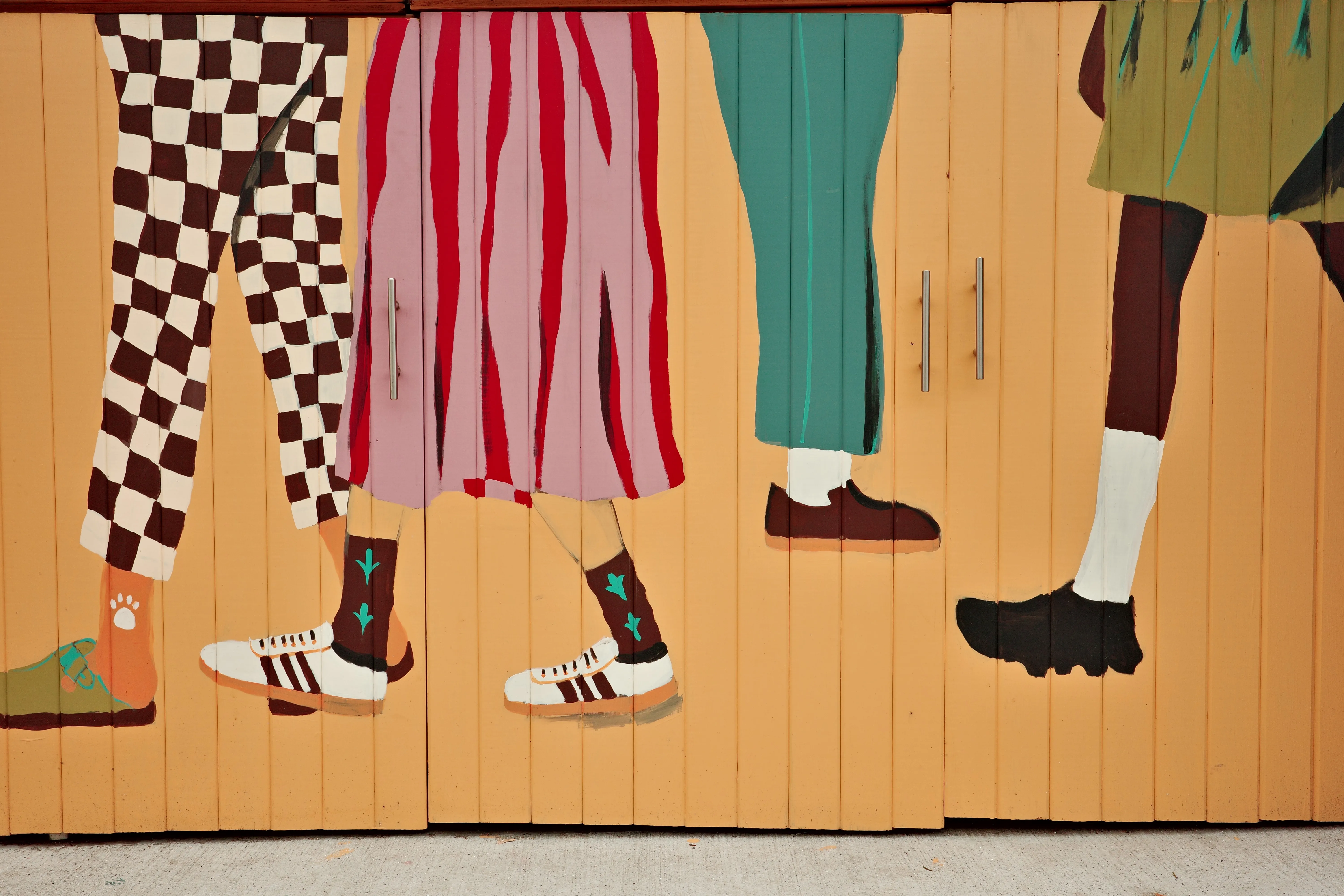 Photo of a mural that depicts the lower half of different people